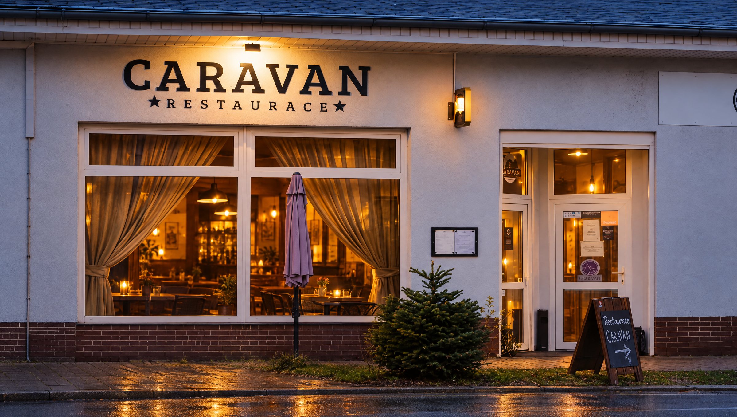 Restaurace Caravan večer, rozsvícená okna a nápis Caravan restaurace nad vchodem